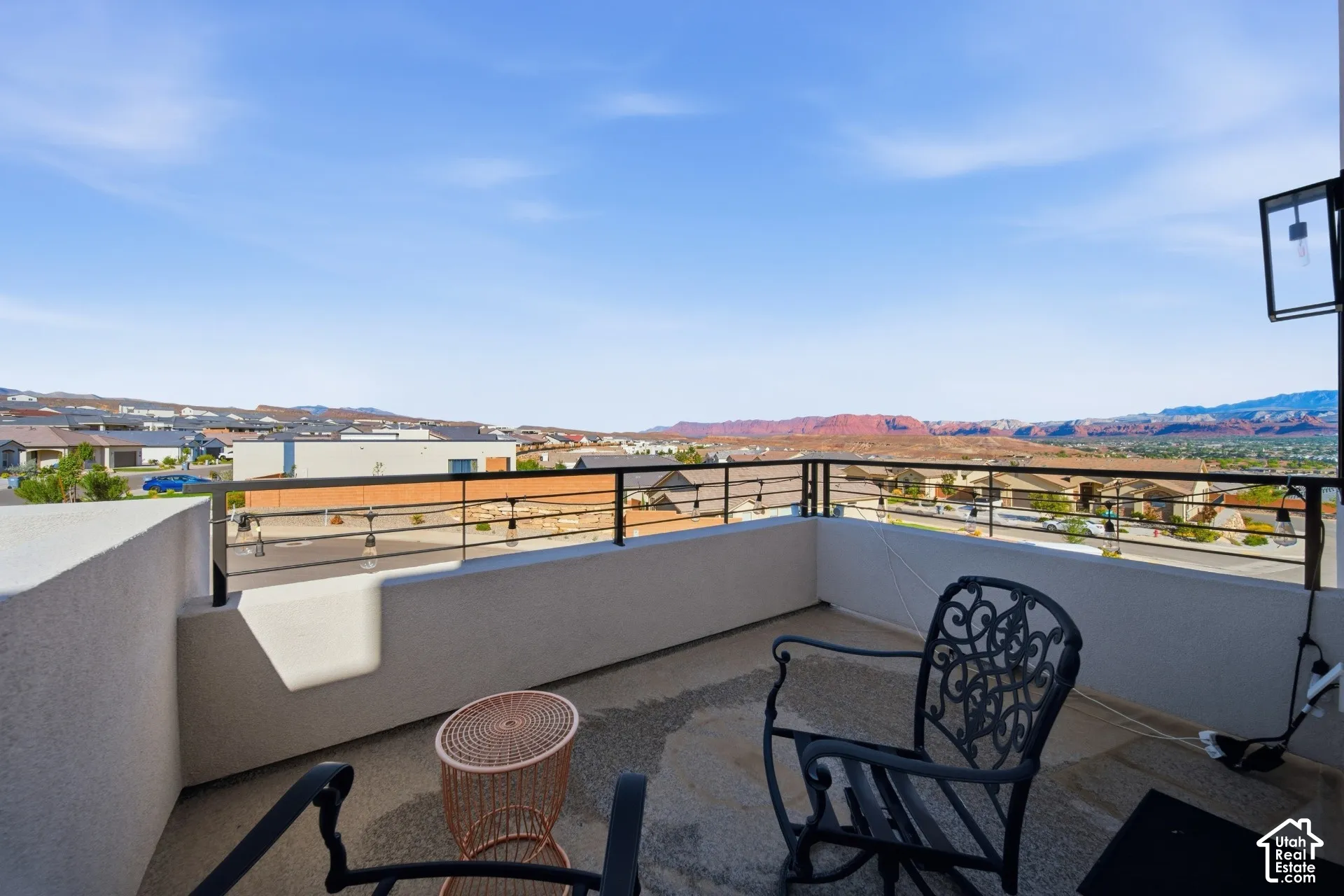 Expansive balcony featuring a concrete surface, black metal railings, and a prominent mountain backdrop
