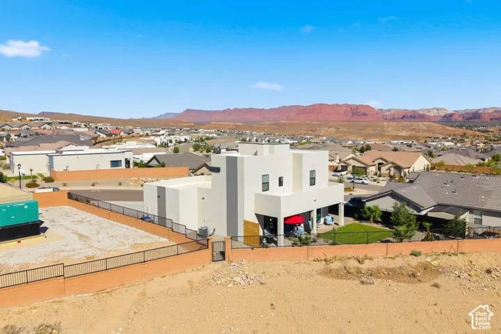 Modern architecture with a flat roofline, an upper-level balcony, a covered patio, and a fenced perimeter
