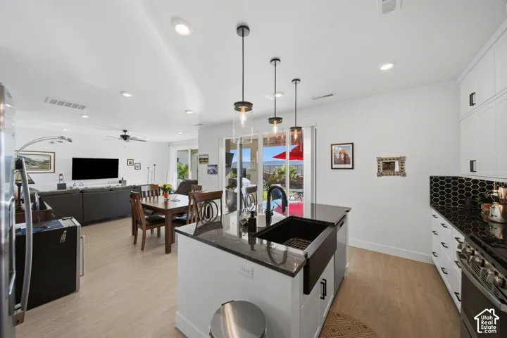Kitchen with a central island, black farmhouse sink, and pendant lighting