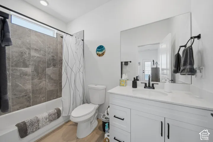 White vanity with black hardware, integrated sink, and a large wall-mounted mirror