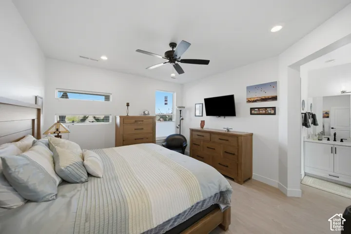 Light wood-finish flooring with white walls and a black ceiling fan