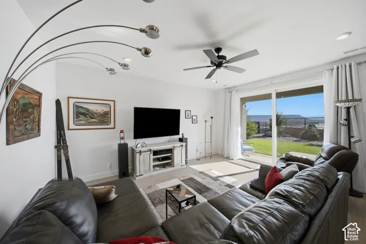 Recessed lighting, ceiling fan, wood-finish flooring, sliding glass door, and a spacious outdoor patio