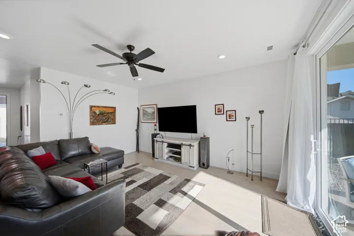 Recessed ceiling lighting, wood-finish flooring, ceiling fan with light fixture, and sliding glass door