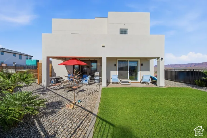 Modern exterior with a covered patio, sliding glass doors, and a manicured lawn