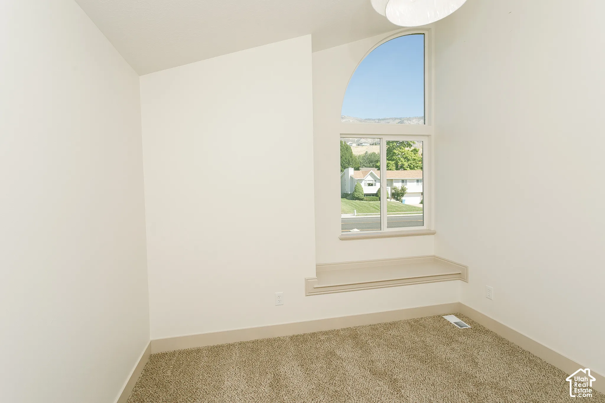 Arched transom window above a fixed pane window, with a built-in window seat
