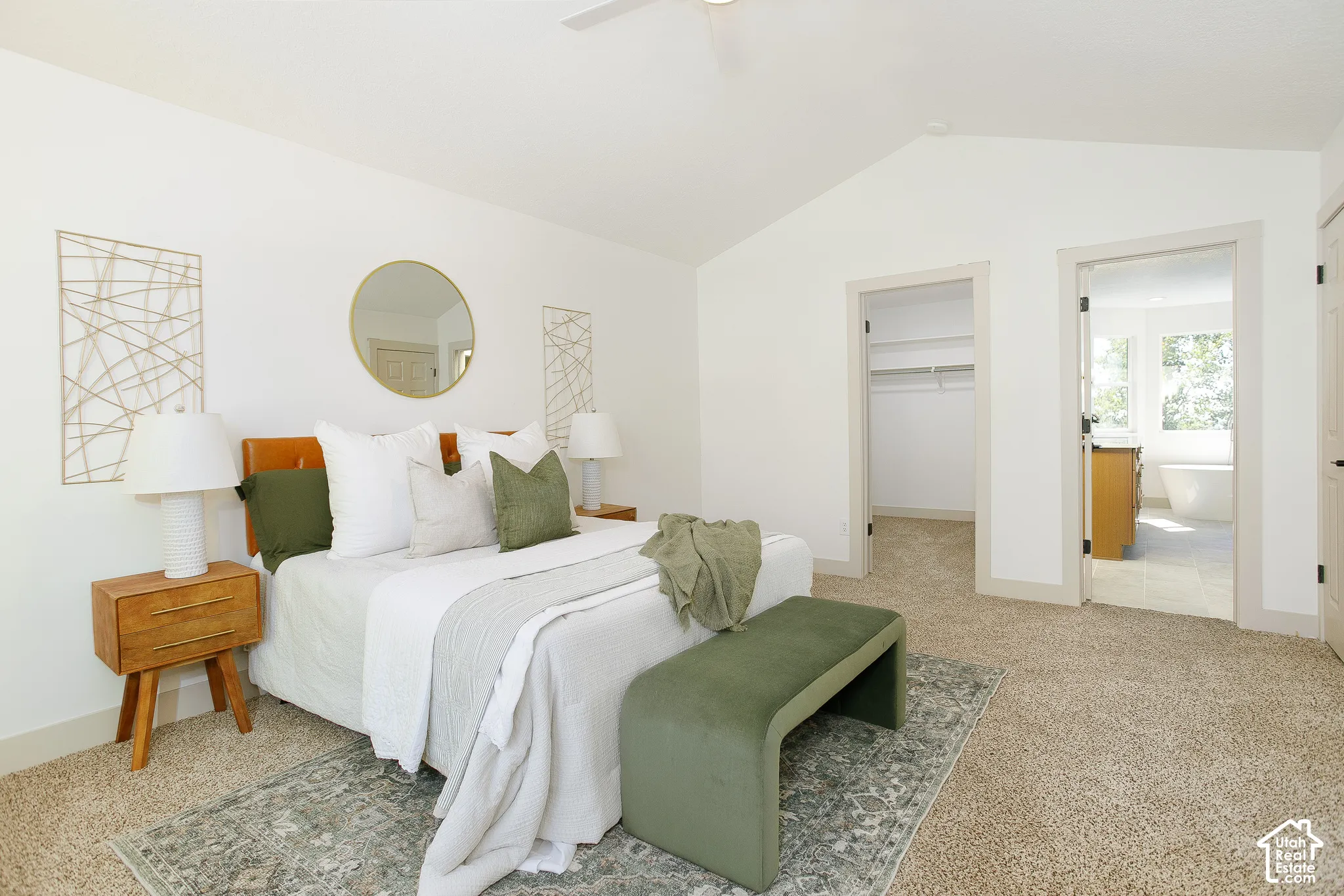 Vaulted ceiling with a ceiling fan, carpeted flooring, and two doorways with trim