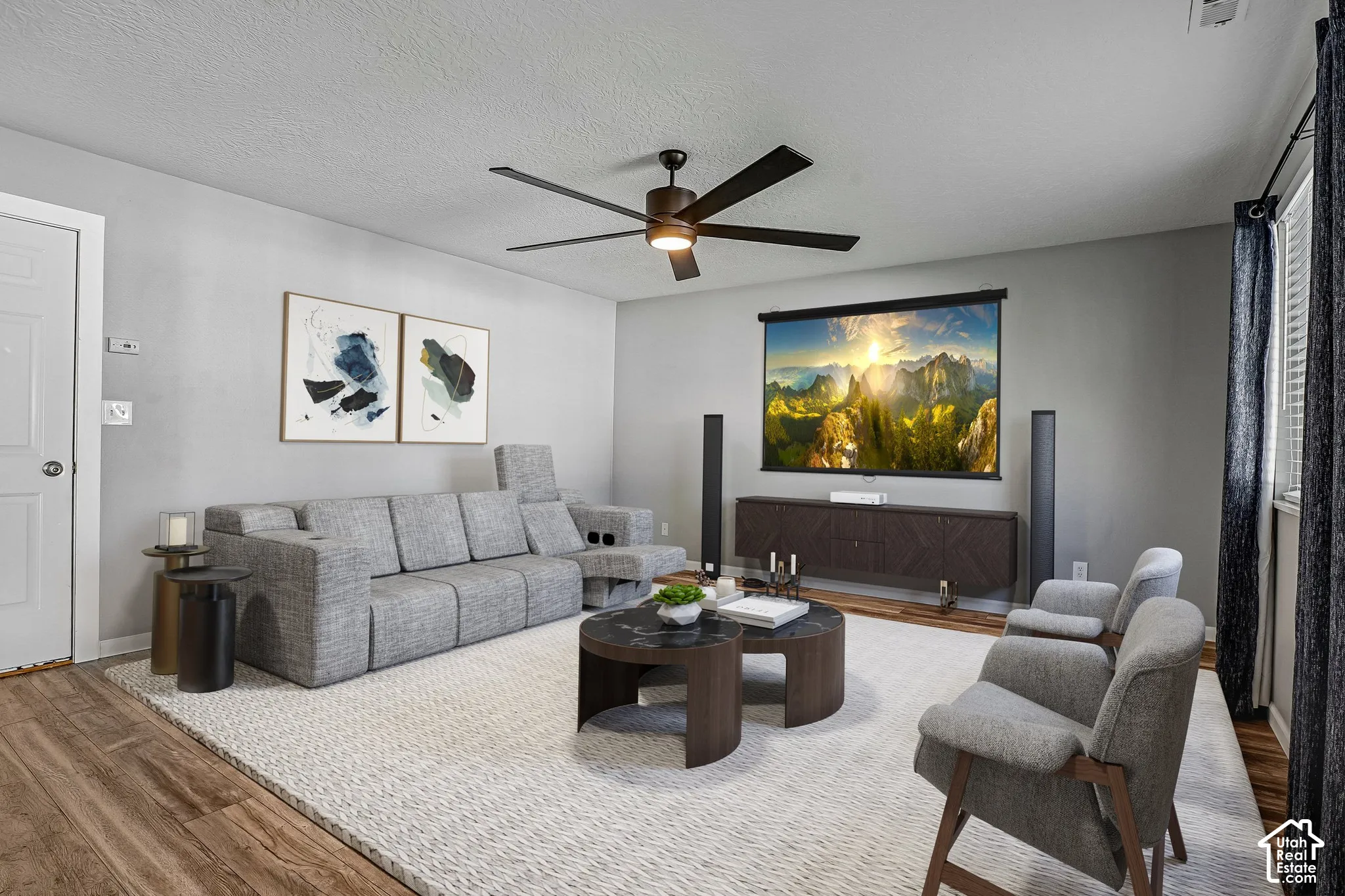 Wood-finish flooring, light gray walls, ceiling fan, and a built-in media console