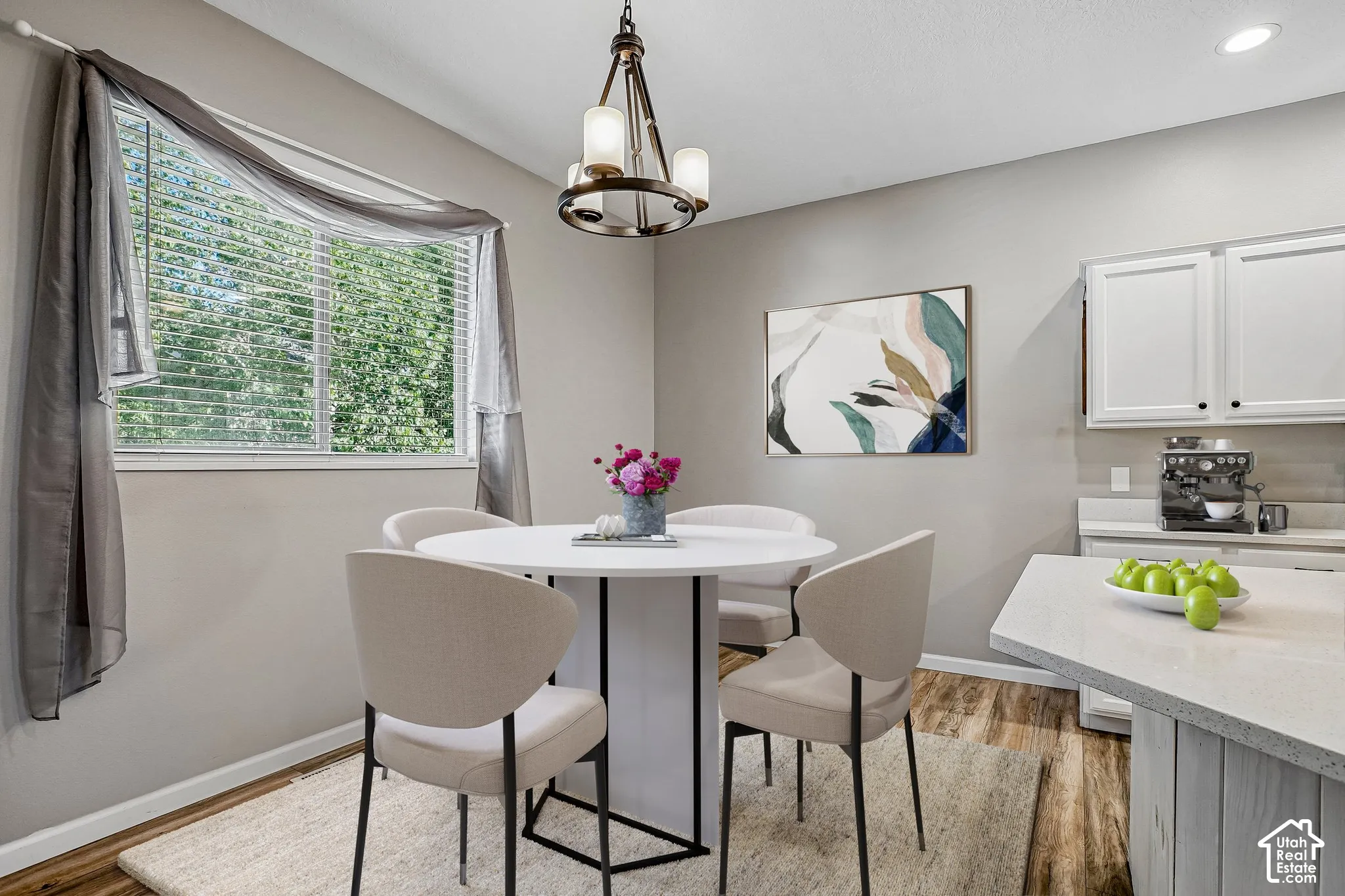 Wood-finish flooring, white cabinetry, and light-toned walls
