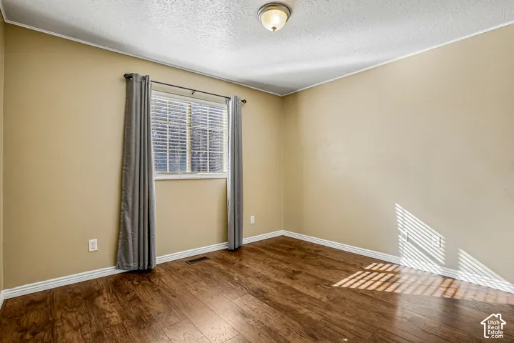 Window with blinds, wood-finish flooring, and a flush mount ceiling light