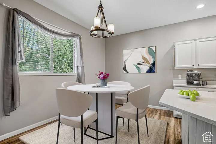 Wood-finish flooring, white cabinetry, and light-toned walls