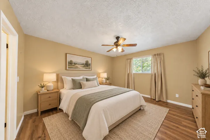 Wood-finish flooring, ceiling fan with integrated lighting, and a window with blinds