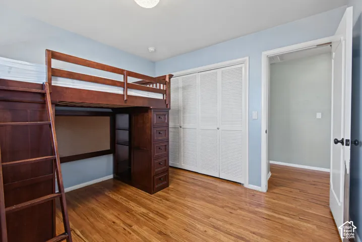 Hardwood flooring throughout, louvered bi-fold closet doors, and light blue wall paint