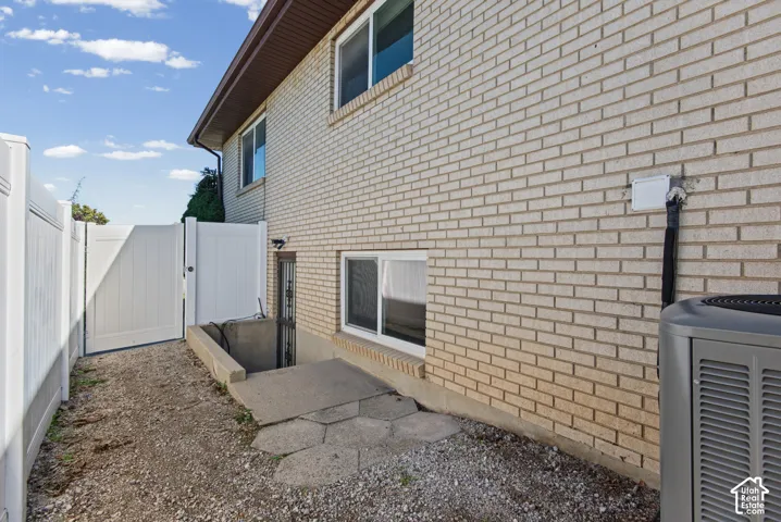 Brick exterior with white vinyl fencing and private side gate