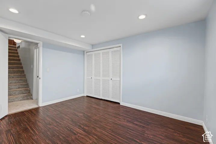 Recessed lighting, wood-finish flooring, and white louvered closet doors