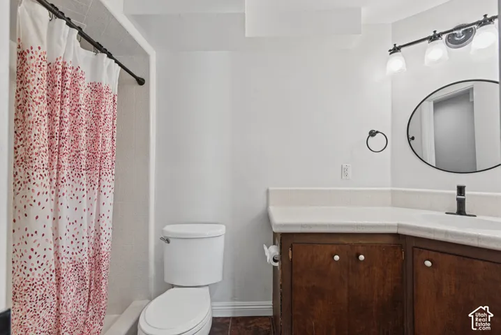 Bathroom featuring a built-in vanity with wood cabinetry, a light-colored countertop, and a white integrated sink with a matte black faucet