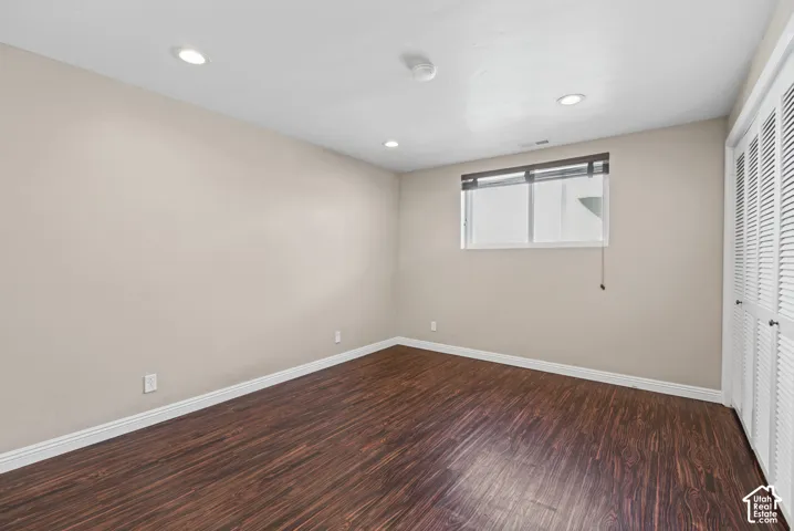 Wood-finish flooring, recessed lighting, and a white window frame with blinds