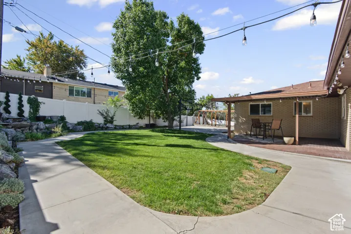 Expansive lawn area with a concrete pathway and mature trees