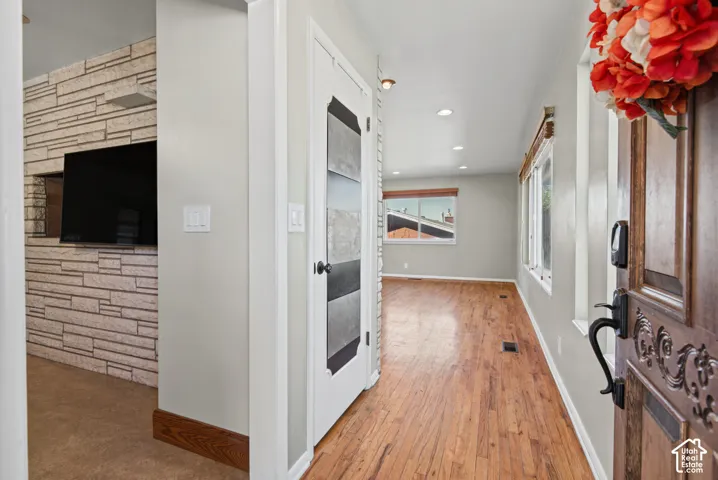Hardwood-finish flooring, recessed lighting, and a carved wooden entry door