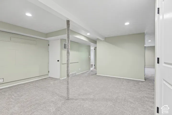 Recessed ceiling lighting, light gray wall paint, gray carpeting, white trim, and white interior doors