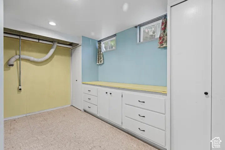 Built-in cabinetry with drawers, recessed lighting, and windows