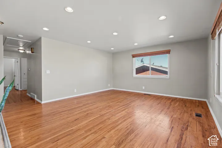 Recessed lighting, wood-finish flooring, and light-colored walls create a bright interior
