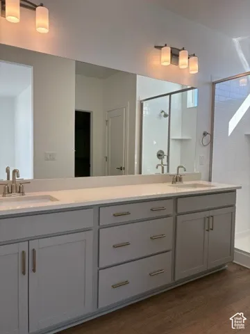 Primary bath with dual vanity with light gray cabinetry, brushed nickel hardware, and white countertops
