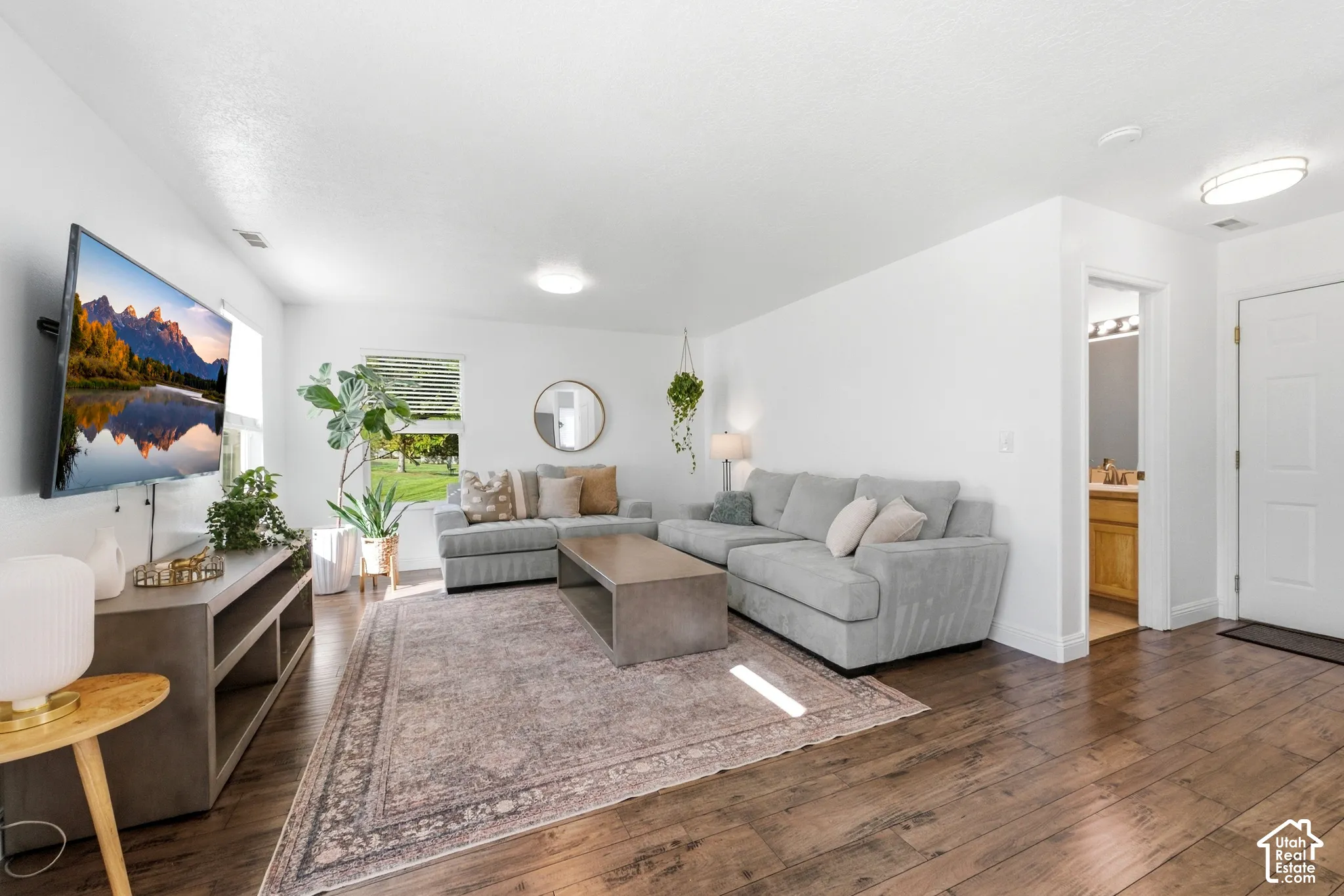 Wood-finish flooring throughout, white walls, recessed lighting, and a window with horizontal blinds