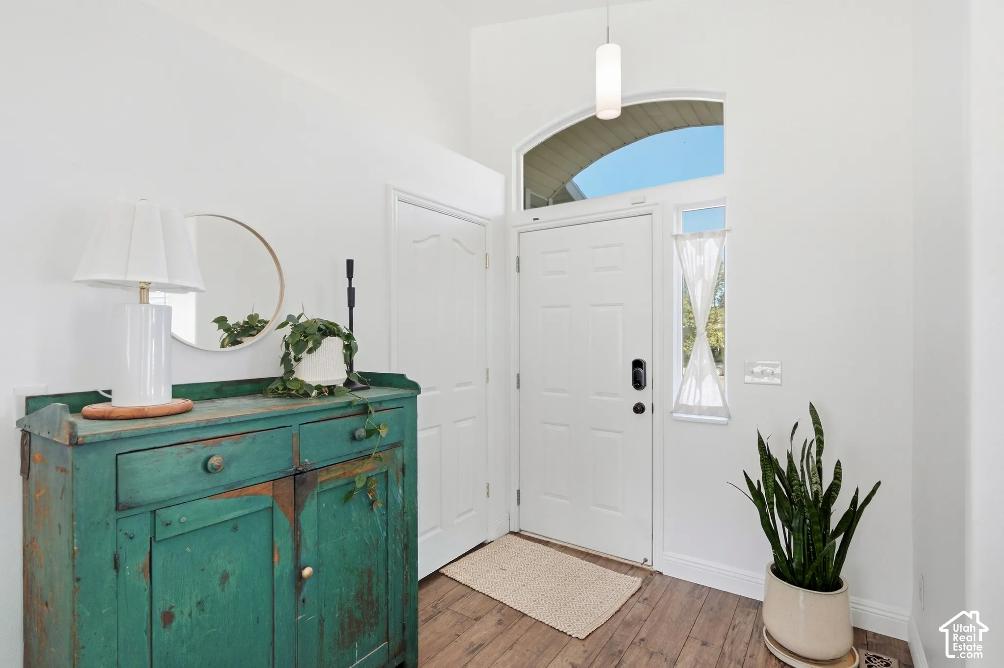 White paneled door with an arched transom window