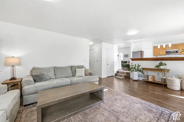 Spacious living area featuring wood-finish flooring, white walls, and recessed lighting