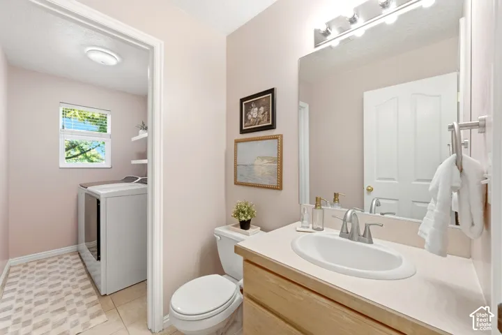 Bathroom with a light wood-finish vanity, integrated sink, and wall-mounted mirror
