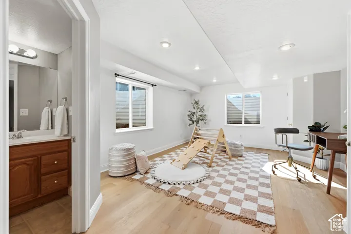 Recessed ceiling lighting, light wood-finish flooring, and white walls