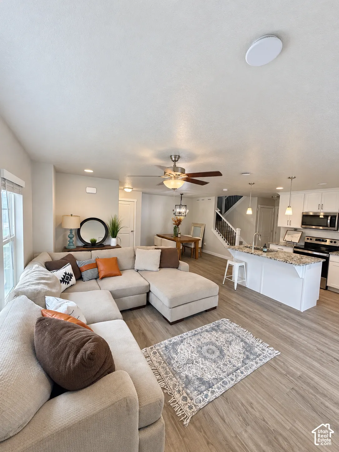 Kitchen featuring white cabinetry, stone countertops, and a central island with pendant lighting