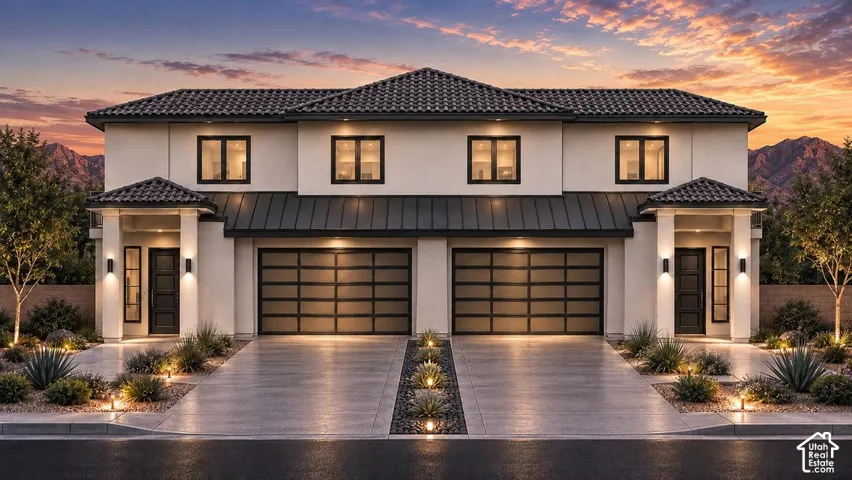 Contemporary stucco exterior with a tiled roof, two-car garage, and integrated landscape lighting
