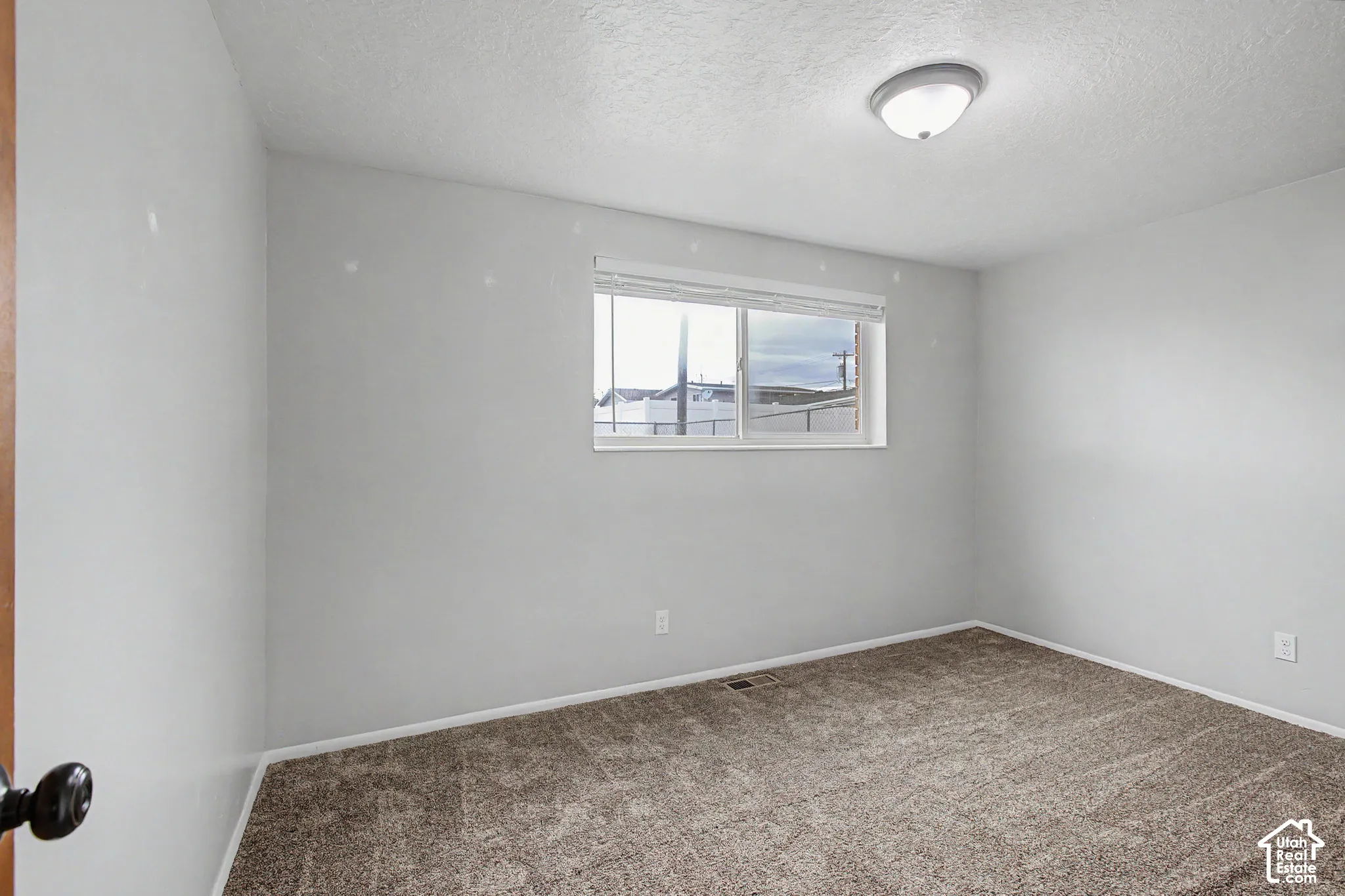 Window with blinds, wall-to-wall carpeting, and a flush mount ceiling light