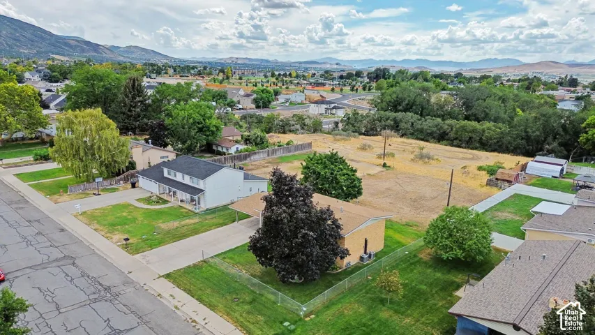 Expansive lot with mountain backdrop, residential street frontage, and established trees