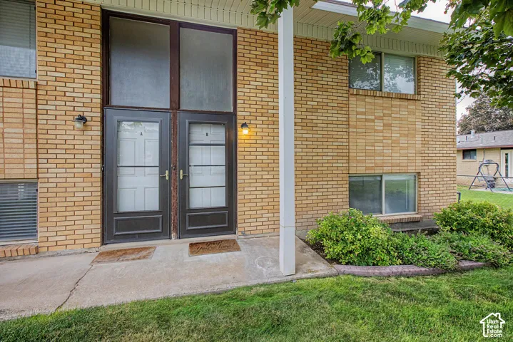 Brick exterior featuring double entry doors, transom windows, and exterior lighting fixtures
