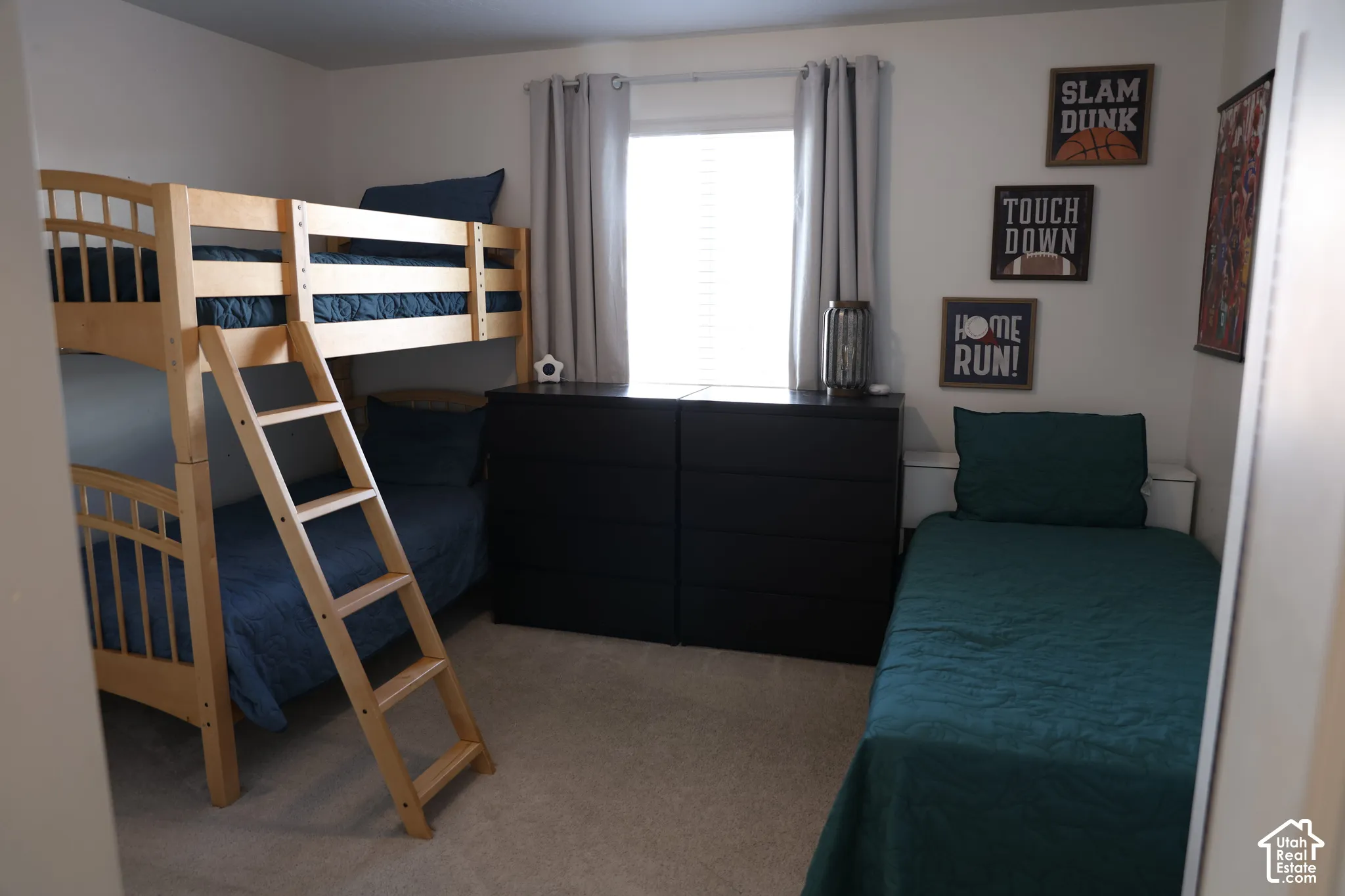 Carpeted room with a window, light gray walls, light wood bunk beds, and a dark wood-finish dresser