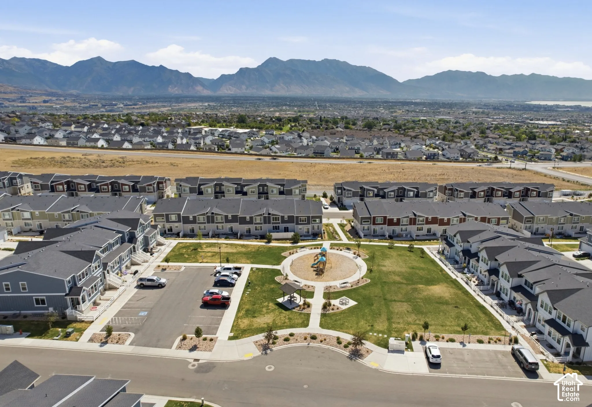 Townhome community with mountain scenery, a central green space, and a playground