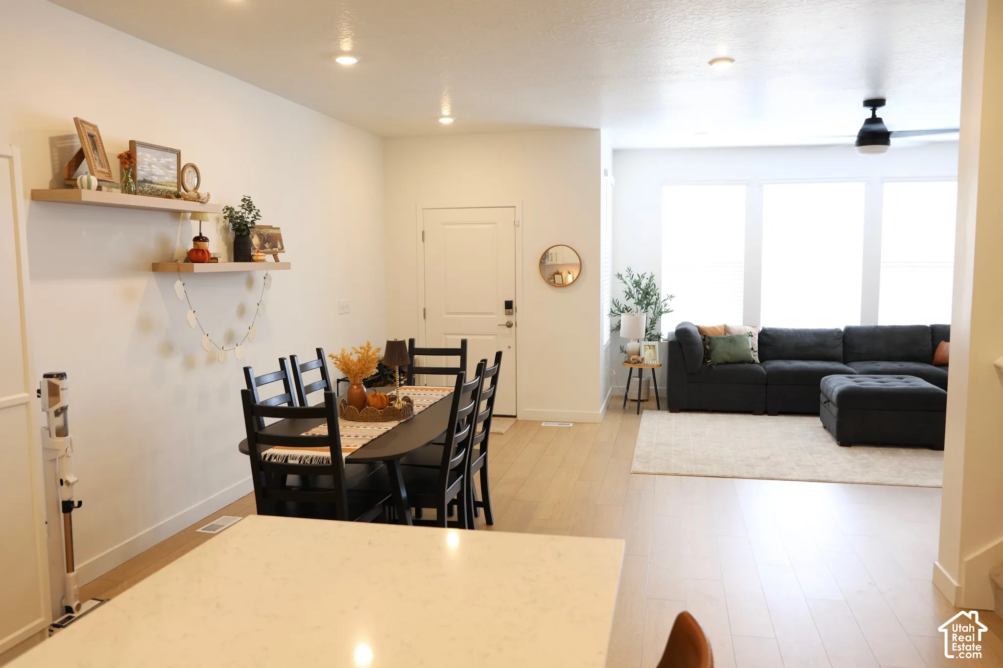 Open-concept living area with wood-finish flooring, recessed lighting, and a contemporary ceiling fan