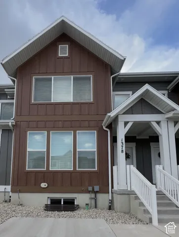 Brown vertical siding exterior with white trim and a gabled roof