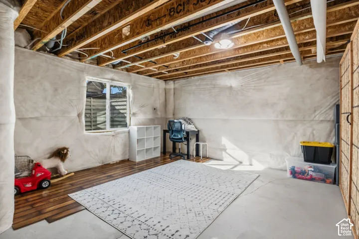 Unfinished basement with exposed ceiling joists and concrete flooring