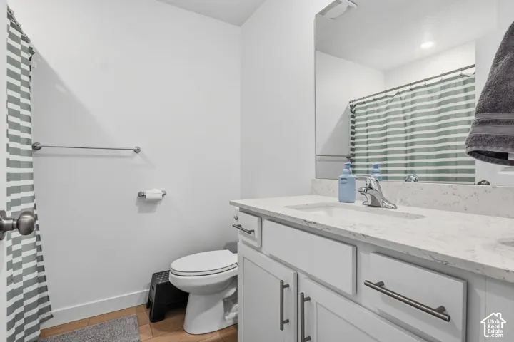 White shaker vanity with chrome hardware, integrated sink, and light-toned countertop