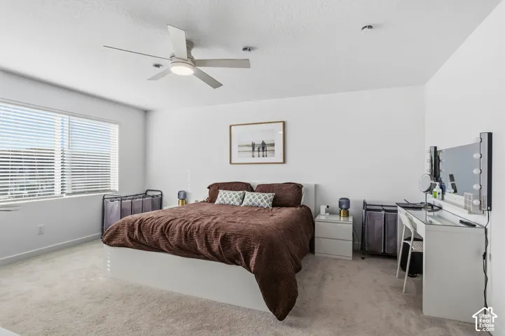Recessed lighting, a ceiling fan with integrated lighting, and carpeted flooring