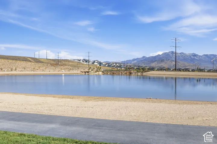 Waterfront property featuring a sandy shoreline and a paved path