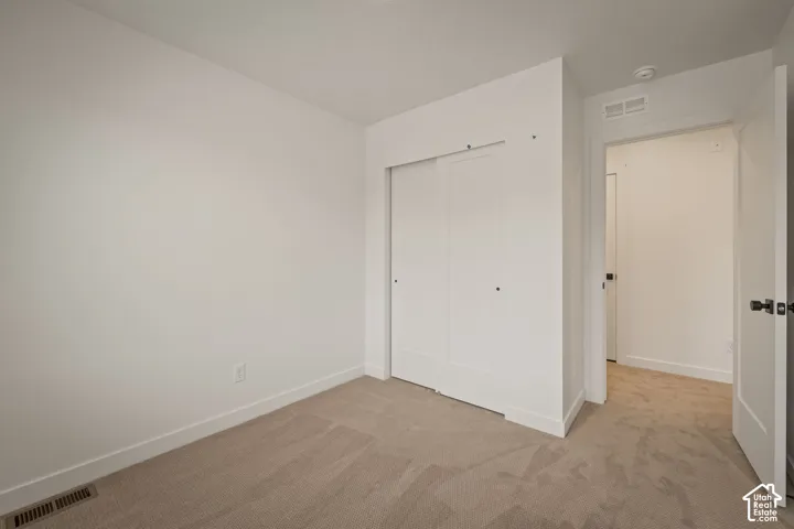 Neutral carpet flooring with white baseboards and walls