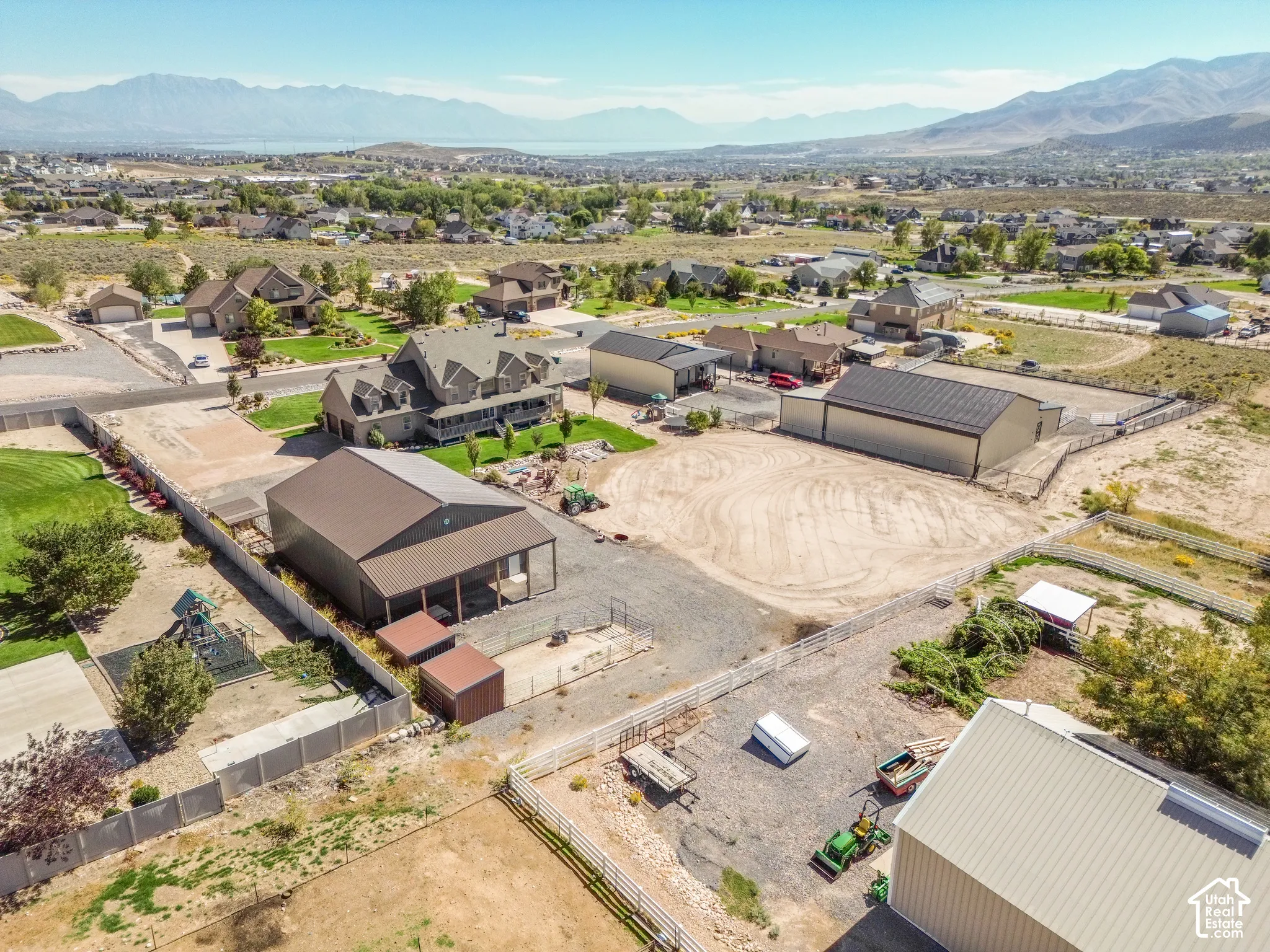Expansive property featuring multiple outbuildings with metal roofs, a sizable main residence, and a spacious lot