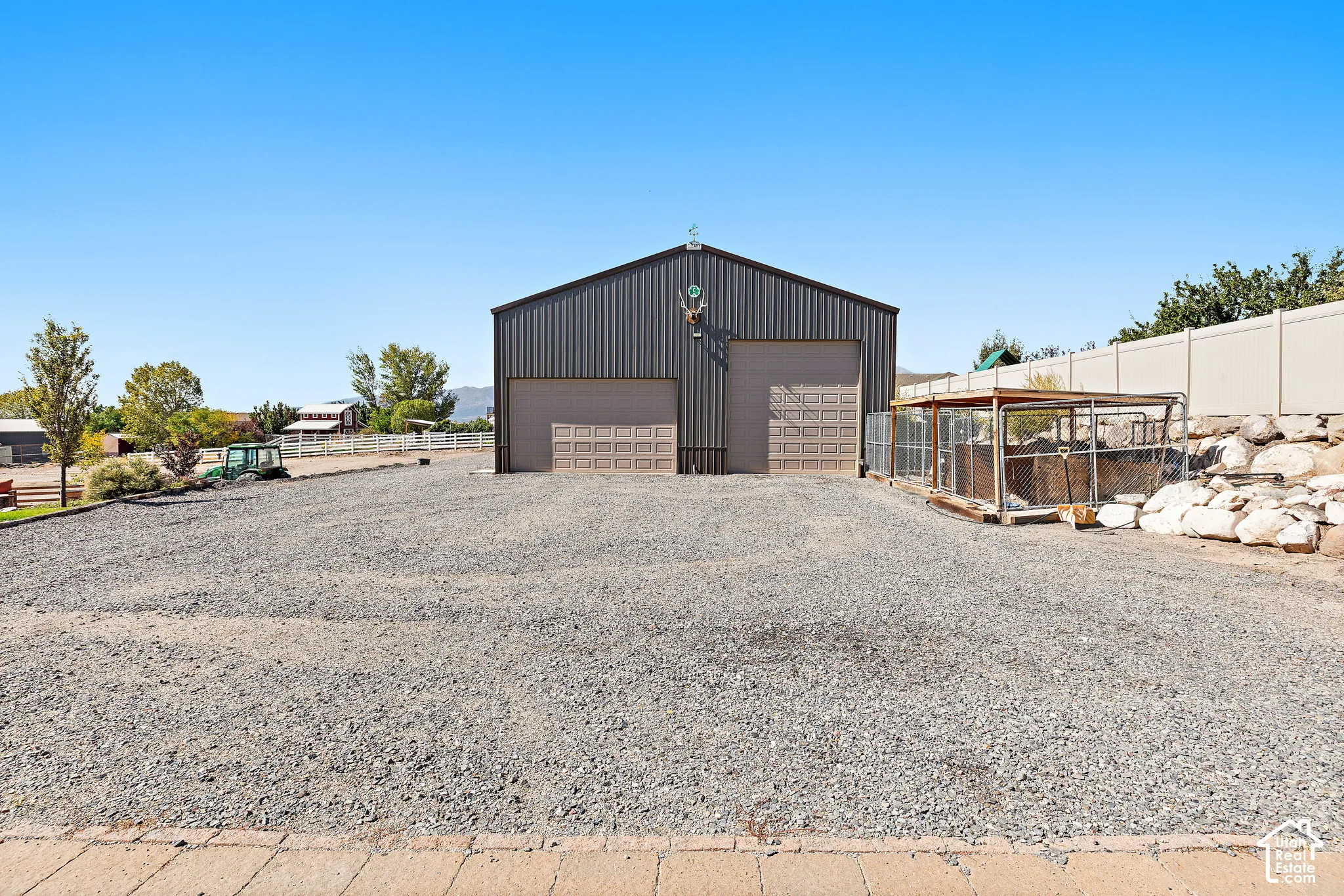 Metal utility building with two roll-up doors and gravel surfacing