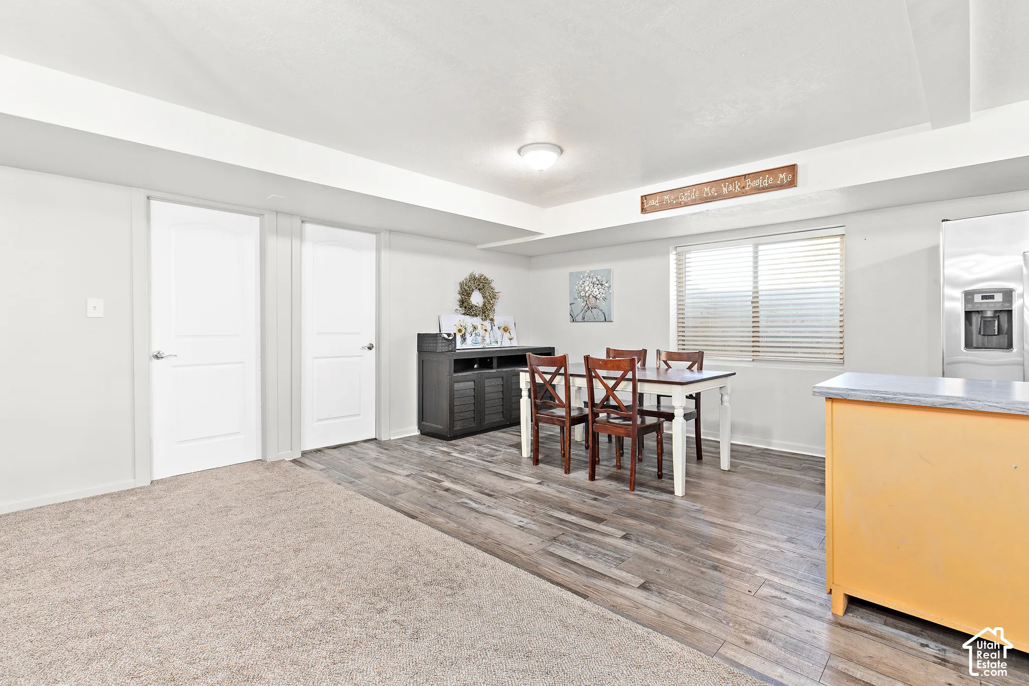 Wood-finish flooring, recessed lighting, and a stainless steel refrigerator