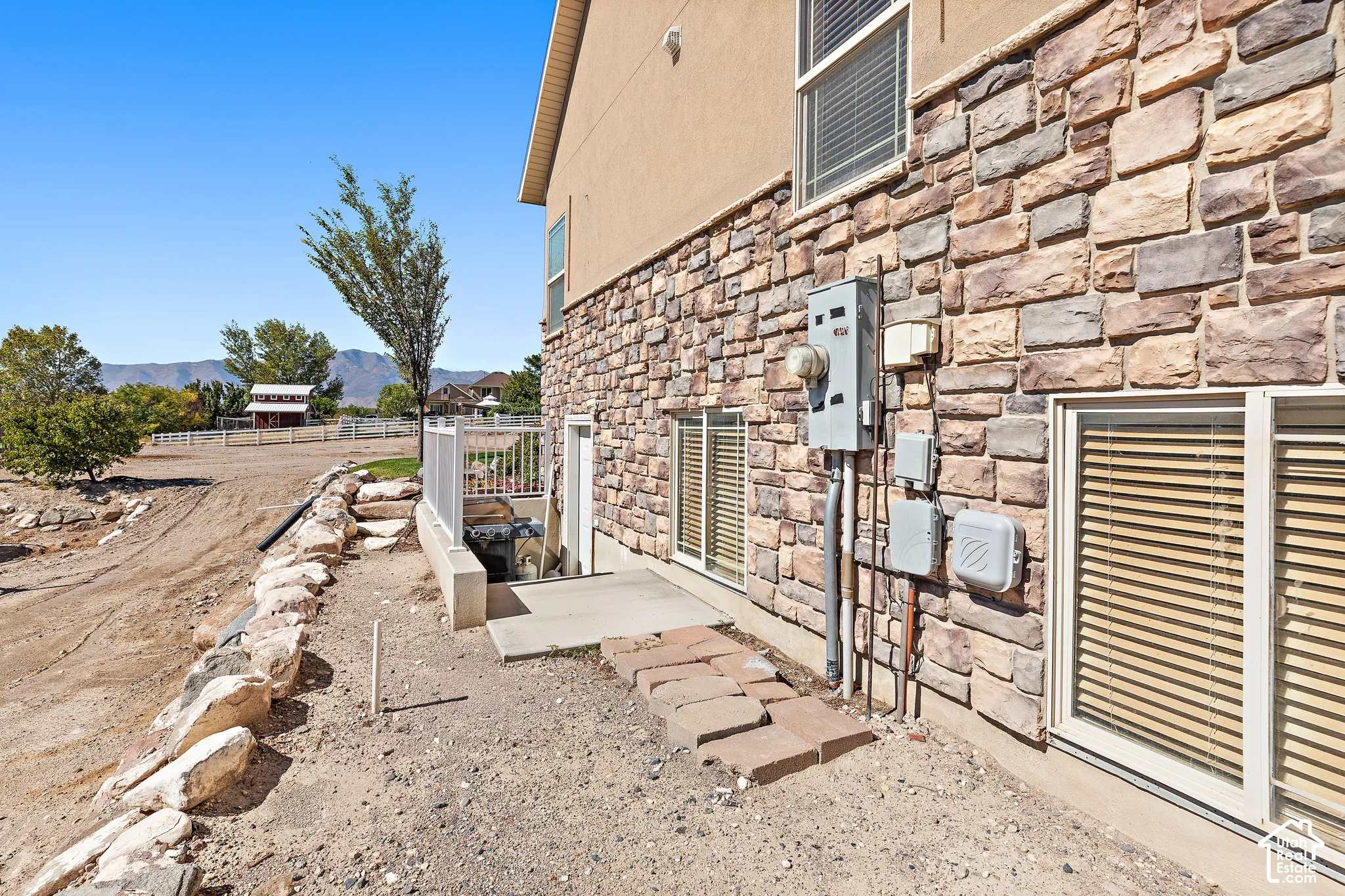 Stone veneer siding and stucco exterior with multiple windows