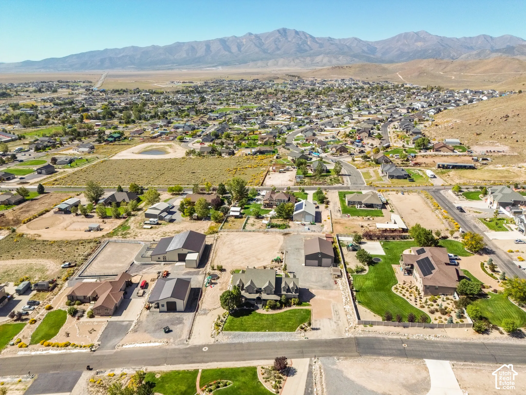 Expansive property featuring multiple outbuildings, landscaped grounds, and mountainous scenery